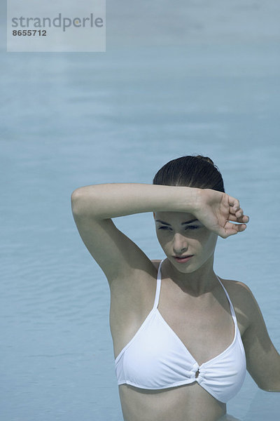 Junge Frau in Schwimmbadabschirmung Augen