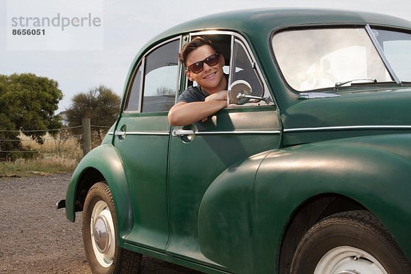 Porträt eines jungen Mannes in vintage morris minor