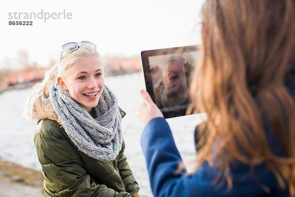 Teenagermädchen fotografiert Freund mit digitalem Tablett