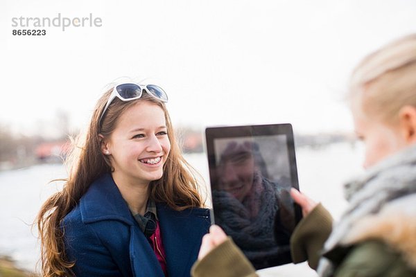 Teenagermädchen fotografiert Freund mit digitalem Tablett