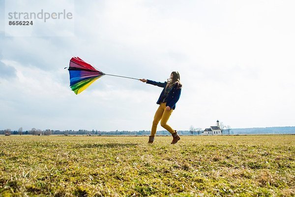 Teenager Mädchen im Feld mit Regenschirm
