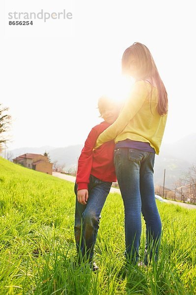 Junge und ältere Schwester im Grasfeld