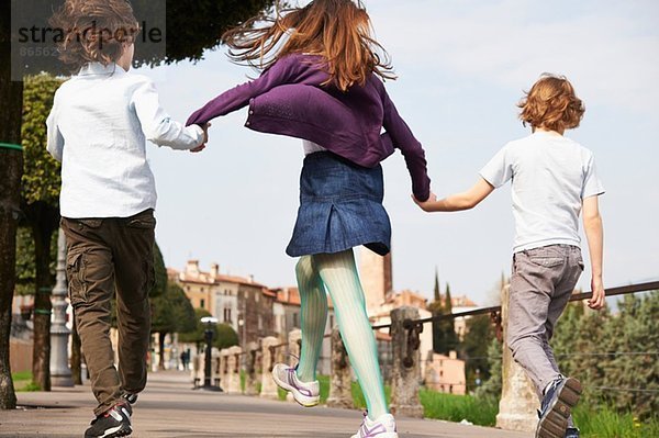 Junge Jungen und ältere Schwester marschieren durch den Park  Provinz Venedig  Italien