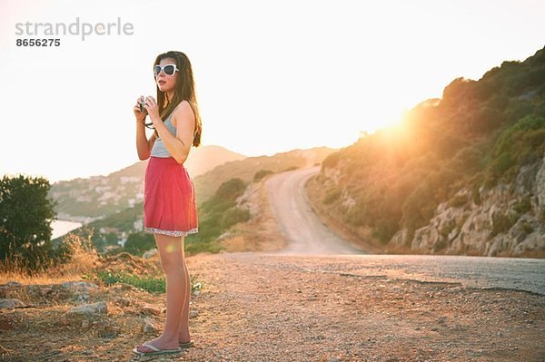 Mädchen hält Kamera bei Sonnenuntergang  Kas  Türkei