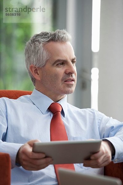 Geschäftsmann mit digitalem Tablett im Büro