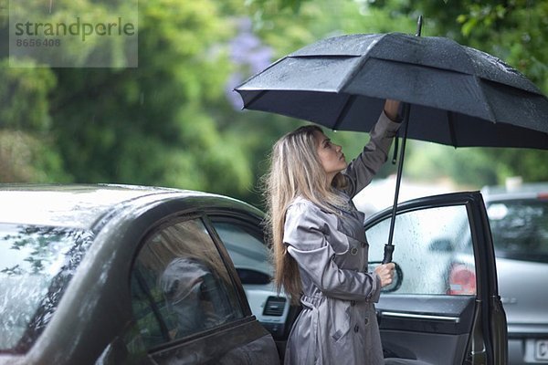 Junge Frau kämpft um den Regenschirm