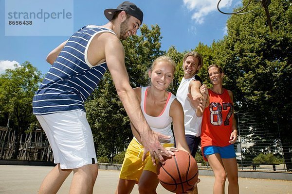 Gruppe von Freunden beim Basketball im Park