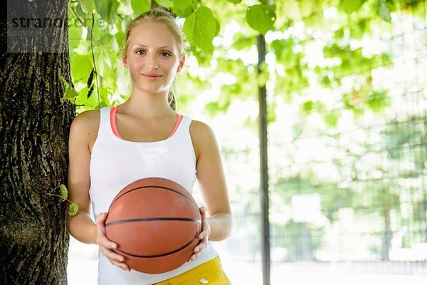 Portrait einer jungen Basketballerin im Park