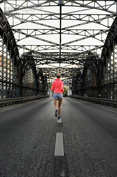 Junge Läuferin überquert Brücke