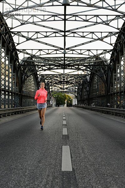 Junge Läuferin über die Brücke