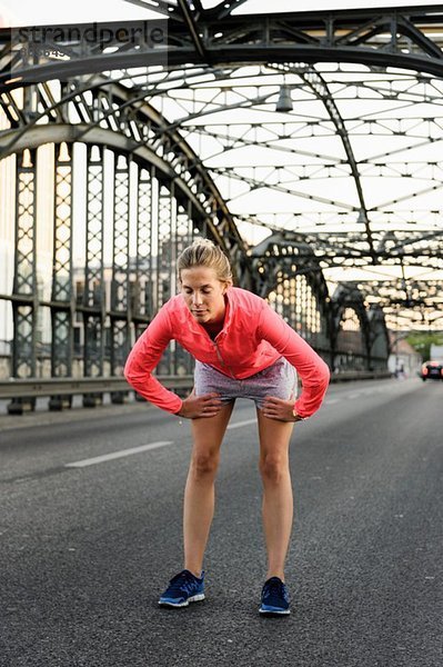 Junge Läuferin beim Laufen auf der Brücke