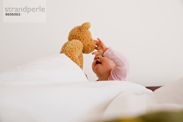 Baby Mädchen spielt mit Teddybär