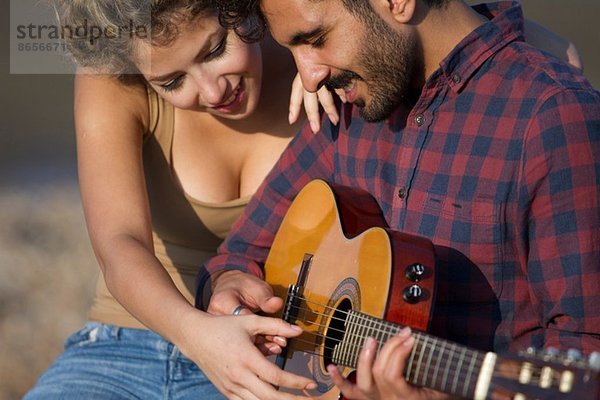 Junges Paar  Mann spielt Gitarre