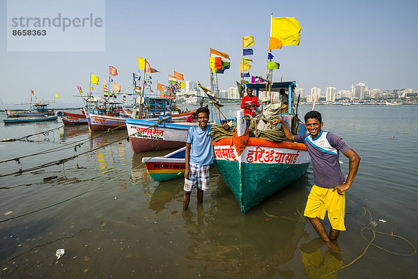 Fischer mit einigen Fischerbooten stehen vor der Skyline der Vorstadt Churchgate in der Back Bay  Mumbai  Maharashtra  Indien