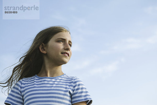 Porträt eines selbstbewussten und glücklichen neunjährigen Mädchens im Freien.