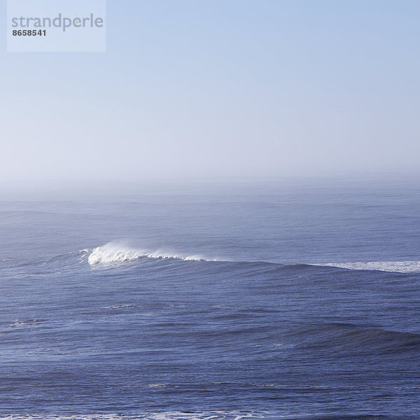 Ein Blick über den Ozean  und eine Welle mit einem sich entwickelnden weißen Kamm.