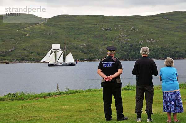 Menschen am Ufer betrachten den niederländischen Zweimast-Topschoner Wylde Swan auf dem Loch Broom  Ullapool  Caithness  Sutherland and Ross  Highlands  Schottland  Großbritannien