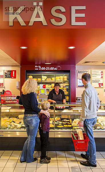 Familie beim Einkaufen an der Käsetheke im Supermarkt  Deutschland