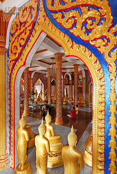 Raum mit prachtvoll verziertem Tor und goldenen Buddhastatuen im Wat Chalong Tempel  Phuket  Thailand