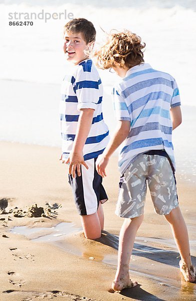 Jungs spielen am Strand