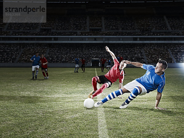 Fußballspieler kicken für Ball auf Feld