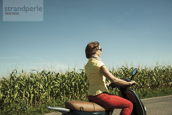 Frau fährt auf einem Roller