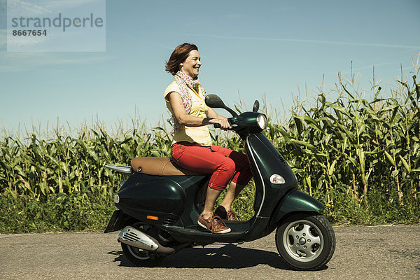 Frau fährt auf einem Roller