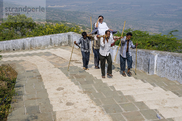 Träger tragen einen Jain-Pilger zum Gipfel des Tempelbergs Shatrunjaya  Palitana  Gujarat  Indien