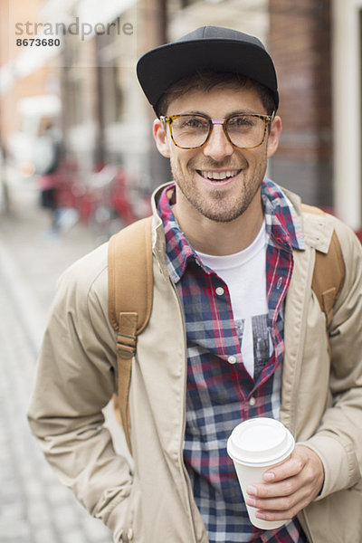 Mann mit Tasse Kaffee auf der Stadtstraße
