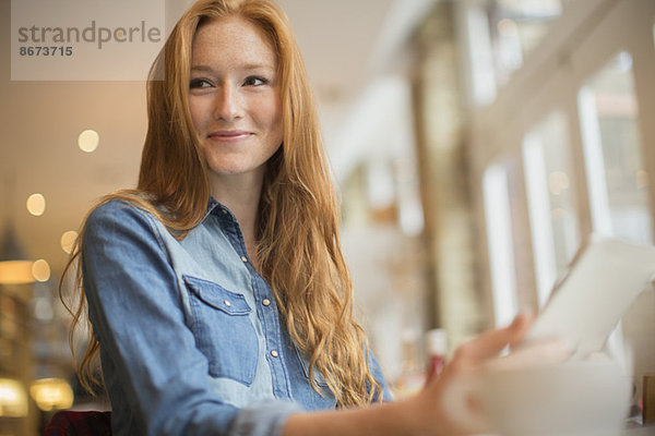 Frau mit digitalem Tablett im Cafe