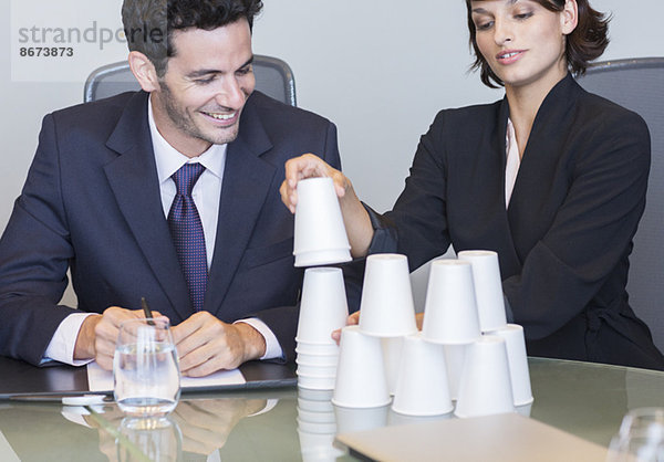 Geschäftsleute stapeln Tassen im Meeting