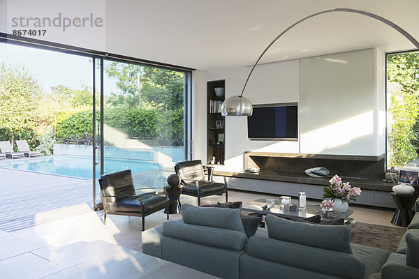 Modernes Wohnzimmer mit Blick auf die Terrasse mit Swimmingpool
