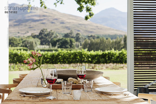 Esstisch und Stühle auf einer luxuriösen Terrasse mit Blick auf den Weinberg