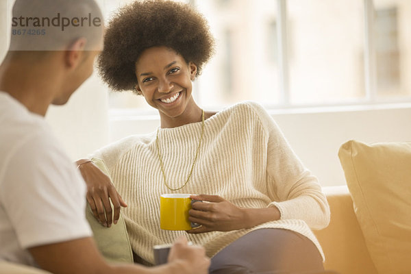 Paar trinkt Kaffee auf dem Sofa