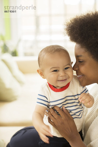 Mutter hält Baby Junge auf Sofa