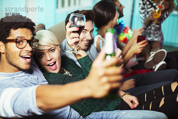 Freunde trinken auf dem Sofa auf der Party