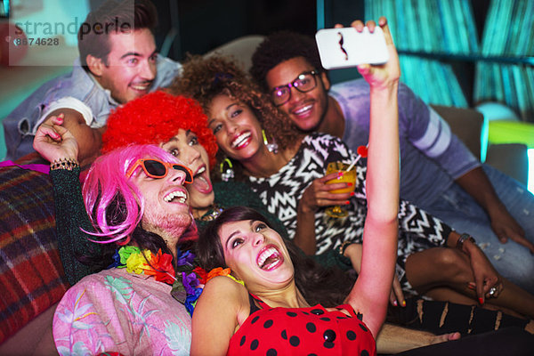 Freunde beim Fotografieren auf dem Sofa auf der Party