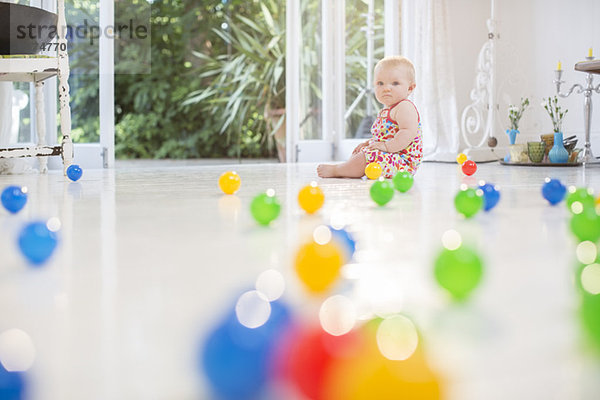 Mädchen mit Spielzeug auf dem Küchenboden