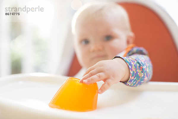 Baby Mädchen beim Essen im Hochstuhl