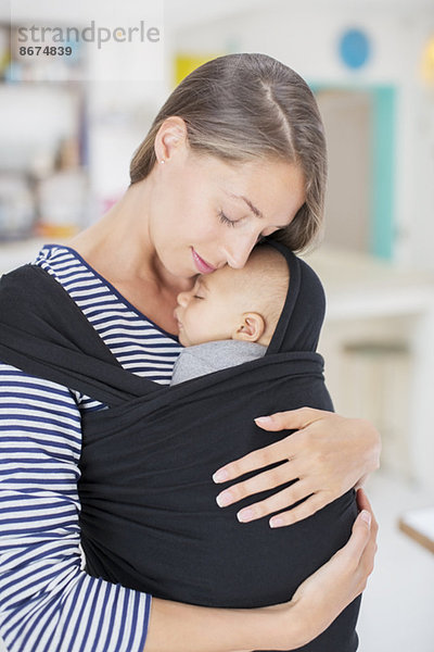 Mutter hält Baby im Tragetuch