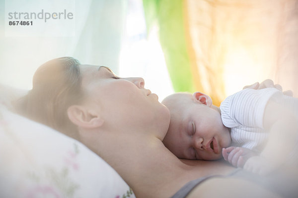 Mutter und kleines Mädchen schlafen auf dem Bett