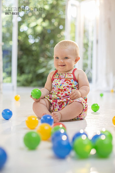 Kleines Mädchen spielt mit Spielzeug auf dem Boden