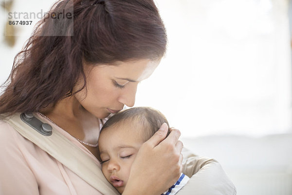 Mutter küsst schlafendes Baby Mädchen