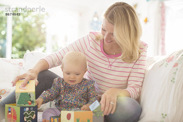 Mutter und kleines Mädchen spielen mit Blöcken