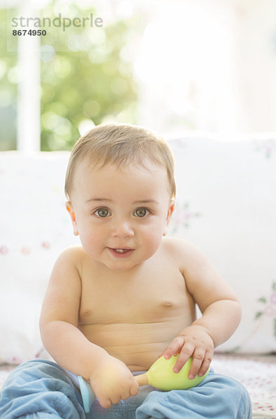 Baby Junge sitzt auf dem Sofa