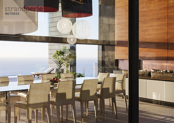 Tisch und Stühle im modernen Esszimmer mit Meerblick