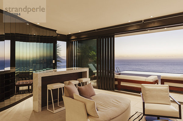 Modernes Wohnzimmer und Bar mit Blick auf das Meer bei Sonnenuntergang