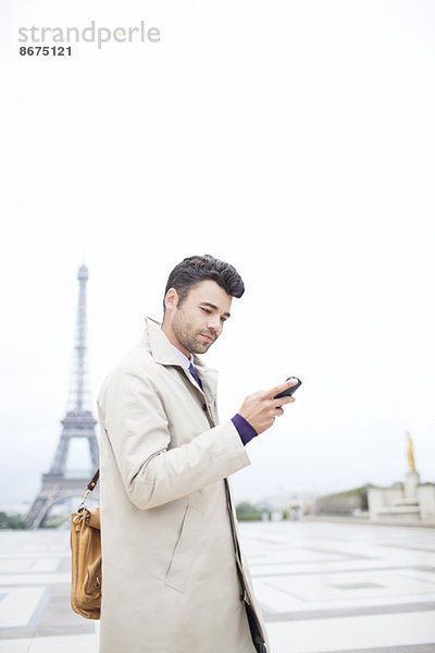 Geschäftsmann mit Handy von Eiffelturm  Paris  Frankreich