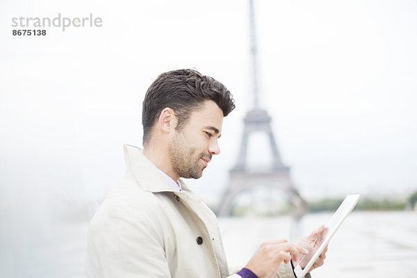 Geschäftsmann mit digitalem Tablett von Eiffelturm  Paris  Frankreich