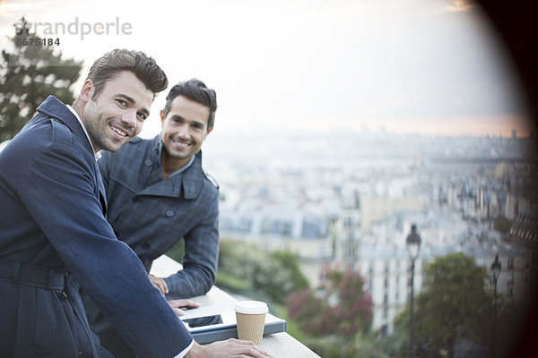 Geschäftsleute lächeln über das Geländer mit Blick auf Paris  Frankreich